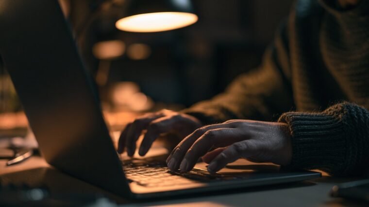 Hands unlocking a laptop using a fingerprint sensor